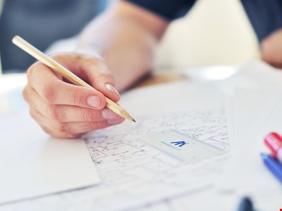 En tjänsteman gör anteckningar på en ritning. 